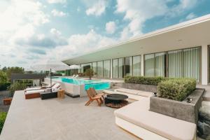 a patio with a swimming pool and a building at Pinepilla Poolvilla Huahin in Hua Hin