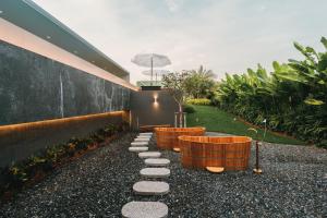 a garden with three wicker tubs on the side of a building at Pinepilla Poolvilla Huahin in Hua Hin