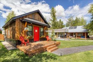a tiny house with a red door and a deck at Alpenhaus | Ski Jackson & Targhee in Victor