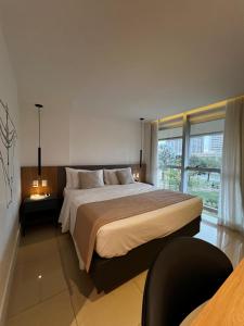 a bedroom with a large bed and a large window at Ap Tryp by Wyndham Nações in Brasília +17 photos