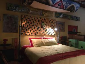ein Schlafzimmer mit einem Bett mit hölzernem Kopfteil in der Unterkunft MAGIC MOUNTAIN WAREHOUSE a 1920 RailroadWonderWarehouse in pristine High Desert with Trains in Jacumba