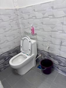 a bathroom with a toilet and a black bucket at DNH Nilam Puri Homestay Unit C in Kota Bharu