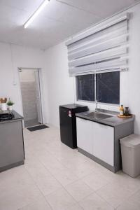a kitchen with black and white counters and a window at DNH Nilam Puri Homestay Unit C in Kota Bharu