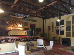 ein Schlafzimmer mit einem Bett und Stühlen in einem Zimmer in der Unterkunft MAGIC MOUNTAIN WAREHOUSE a 1920 RailroadWonderWarehouse in pristine High Desert with Trains in Jacumba