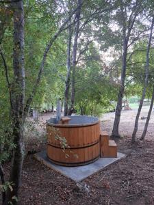 a wooden hot tub in the middle of a forest at Refugio El Rocio lodge tinaja,piscina,bosque in Nacimiento