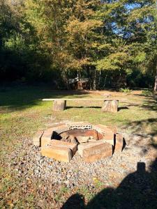 a brick fire pit in the middle of a field at Refugio El Rocio lodge tinaja,piscina,bosque in Nacimiento +4 photos