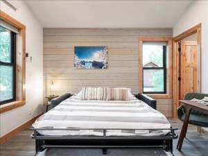 a bedroom with a large bed and two windows at Alpenhaus | Ski Jackson & Targhee in Victor