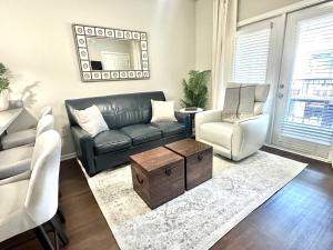 a living room with a couch and a chair and a table at Walk to Stadium & Cotton District, Balcony & Pool in Starkville