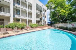a swimming pool in front of a building at Walk to Stadium & Cotton District, Balcony & Pool in Starkville