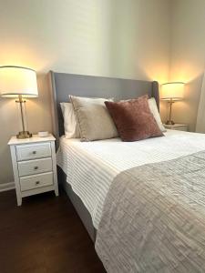 a bedroom with a bed with two lamps on it at Walk to Stadium & Cotton District, Balcony & Pool in Starkville