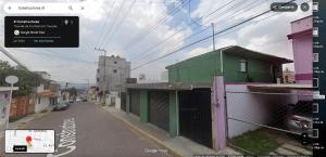 a street with a green building on the side of the road at Habitación cerca del centro de Tlaxcala in Ocotlán