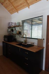 a kitchen with a counter with a sink and a window at Amoré Cabin in Ocean View
