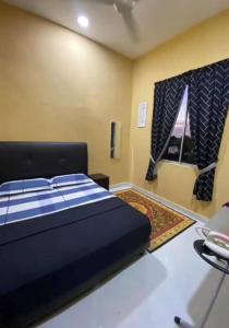a bedroom with a large bed and a window at D'Shazly Homestay Village in Arau