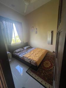 a bedroom with a bed and a window at D'Shazly Homestay Village in Arau