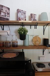a shelf with pots and a plant on it at Amoré Cabin in Ocean View