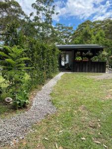 a garden rendering of a house with a gravel path at Amoré Cabin in Ocean View +7 photos