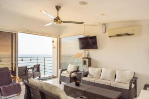 a living room with a couch and chairs and a tv at Villa Malibu in Taganga