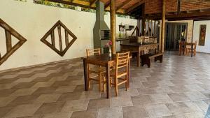 a dining room with a table and chairs on a tile floor at Chalés Água de Coco in Boicucanga