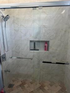 a shower with a glass door with a bottle of soap at 31 Runaway Meadows in Belle Air Summit