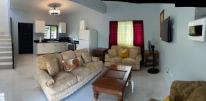 a living room with two couches and a kitchen at 31 Runaway Meadows in Belle Air Summit +3 photos