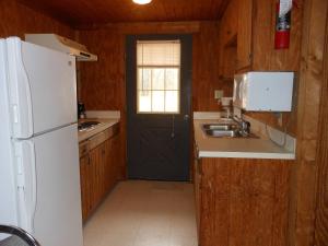 cocina con nevera blanca y fregadero en Bay Landing Camping Resort Cabin 1, en Bridgeport