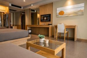 a bedroom with a bed and a table and a desk at The Senses Resort & Pool Villas, PHUKET in Patong Beach