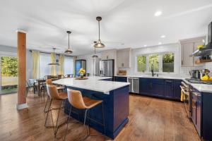 a kitchen with blue cabinets and a large island at KPT Salt Pine House Apartment in Kennebunkport