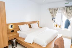 a bedroom with a large white bed and a window at Star Hotel & Suites in Abuja