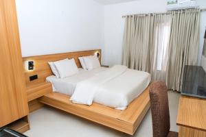 a bedroom with a white bed and a television at Star Hotel & Suites in Abuja