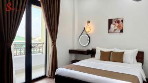 a bedroom with a bed and a large window at New Sitơ Hotel in Quảng Ngãi
