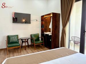 a hotel room with a bed and a desk and chairs at New Sitơ Hotel in Quảng Ngãi