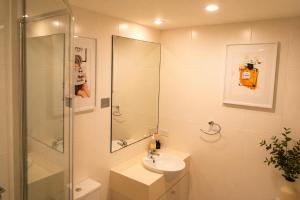 a white bathroom with a sink and a shower at Beautifully Restyled Studio Apartment - Oaks Pacific Blue - Sea Salt Escape in Salamander Bay