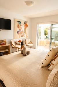 a bedroom with a large bed with a television on the wall at Beautifully Restyled Studio Apartment - Oaks Pacific Blue - Sea Salt Escape in Salamander Bay