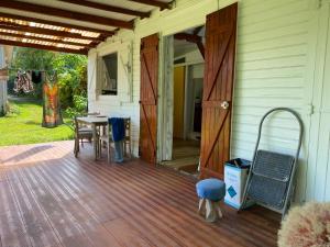 an open door to a porch with a table and chairs at Maison créole in Lamentin