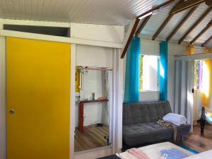 a living room with a couch and a yellow door at Maison créole in Lamentin