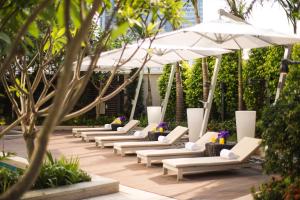 a row of white lounge chairs with umbrellas at Ascott Macau in Macau