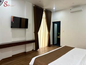 a bedroom with a bed and a television on the wall at New Sitơ Hotel in Quảng Ngãi +47 photos