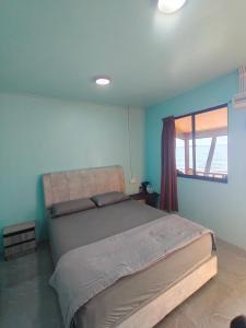 a bedroom with a large bed in a room with a window at Permata Beach Chalet in Kampong Juara