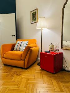a living room with a orange couch and a red suitcase at Art Boutique Residence - City Center - Calea Victoriei in Bucharest