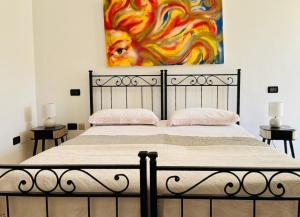a bedroom with a bed with a painting on the wall at Casale Kintsugi in Cepagatti
