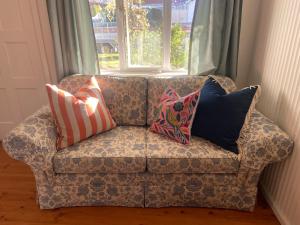 a couch with pillows on it in front of a window at Birchmoore Studio in Penola