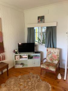 a living room with a television and a chair at Birchmoore Studio in Penola