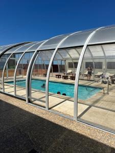 a large metal building with a swimming pool at Hotel Riviera in Las Grutas