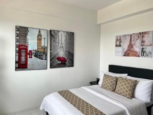 ein Schlafzimmer mit vier Bildern an der Wand in der Unterkunft Luxee Haven in Manila + 13 Fotos