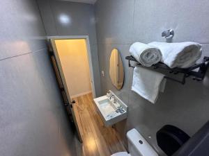 a small bathroom with a toilet and a mirror at Suítes Modernas com Ar-Condicionado e Estacionamento in Hortolândia +20 photos
