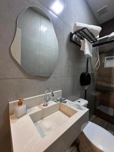 a bathroom with a sink and a mirror on the wall at Suítes Modernas com Ar-Condicionado e Estacionamento in Hortolândia