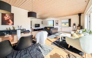 a living room with a table and chairs at 4 Bedroom Cozy Home In Allinge in Allinge