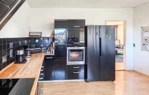 a kitchen with a black refrigerator and a stove at 4 Bedroom Cozy Home In Allinge in Allinge +10 photos