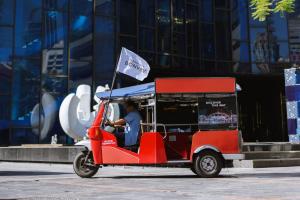 a person driving a red golf cart with a flag at Renaissance Bangkok Ratchaprasong Hotel in Bangkok