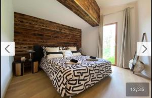 a bedroom with a large bed with a wooden headboard at Villa d'excellence vue lac in La Salle-en-Beaumont